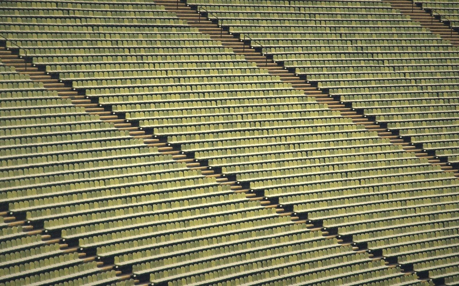 A packed stadium stand viewed from high up and far away